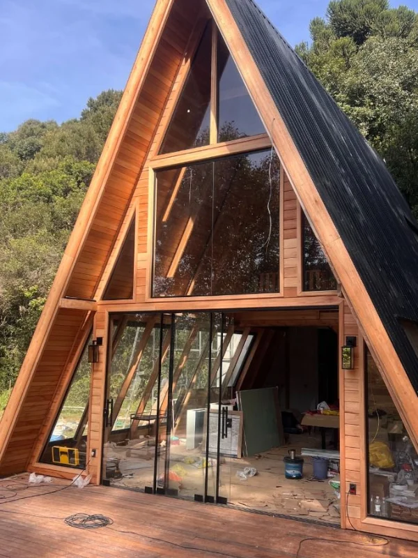 Chalé A-frame em construção mostrando estrutura de madeira