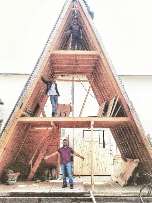 Estrutura A-frame em construção com trabalhadores montando